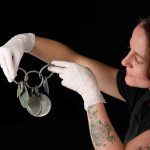 Conservator-Bethan-Bryan-holds-the-bronze-rattle-pendant.-Photo-©-National-Museums-Scotland-1-150x15.jpeg
