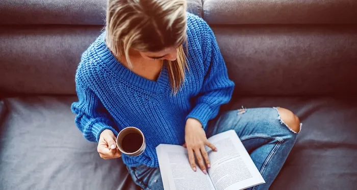 woman-reading-in-sweater-with-coffee.jpg.webp.webp