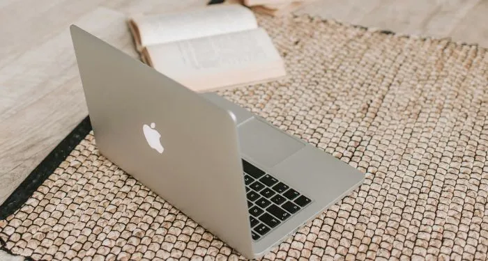 open-laptop-and-book-on-a-beige-rug.jpg.webp.webp